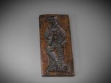 une plaque en bois sur laquelle figure un homme tenant une épée