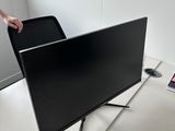 une personne debout à côté d'un téléviseur à écran plat posé sur un meuble