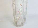 a glass vase with a floral design on it
