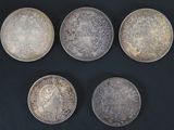 six types différents de pièces d'argent sur une surface noire