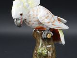 figurine en porcelaine représentant un cacatoès perché sur une souche d'arbre