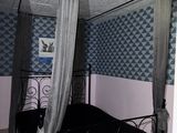 un lit à baldaquin dans une chambre au papier peint bleu et blanc