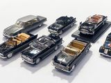 several toy cars are lined up in a row on a white surface