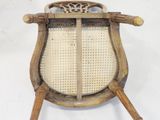 an old wooden chair with a woven seat and wooden legs