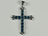 une croix en argent ornée de cristaux bleus sur fond blanc