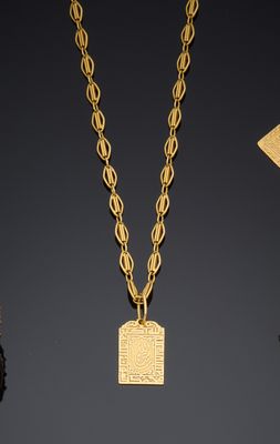 un collier en or avec un petit pendentif carré au bout d'une chaîne