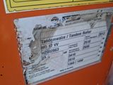 a sign on the side of an orange machine that has a sticker on it