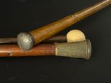 two baseball bats and a ball on a black surface