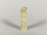 un gros plan d'un morceau de quartz jaune sur une surface blanche