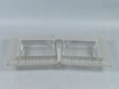 pair of clear glass ashtrays on a white background