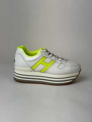a pair of white sneakers with neon yellow accents on the sole