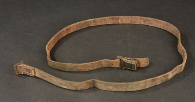 a close up of a belt with a metal buckle on a black surface