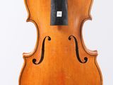 un vieux violon avec un archet accroché à son dos