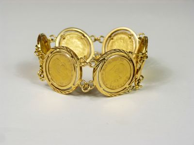 gros plan d'un bracelet en or sur une surface blanche