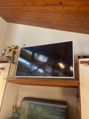 une télévision à écran plat posée sur une étagère en bois