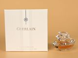gros plan d'un flacon de parfum à côté d'une boîte