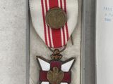 a small medal in a box with a note in it