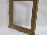 a gold framed mirror sitting on top of a white table