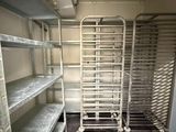 a metal rack in the middle of a room with shelves
