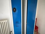 two blue lockers next to a radiator in a room