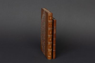 deux livres marron posés l'un sur l'autre sur une surface noire