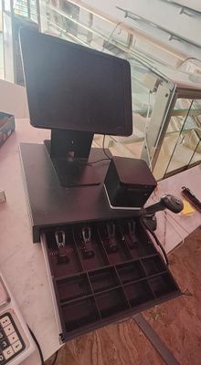 a desk with a monitor, keyboard, and other items on it