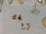 many different types of necklaces and earrings on the table