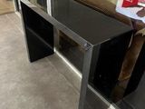 a black table with a glass top in front of a glass door