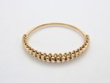 un gros plan d'un bracelet en or orné de petites perles