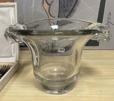 a glass vase sitting on a table next to a pair of scissors