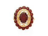 un gros plan d'une bague ornée d'une pierre rouge entourée de grenats