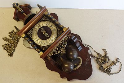 une horloge accrochée au mur par une chaîne