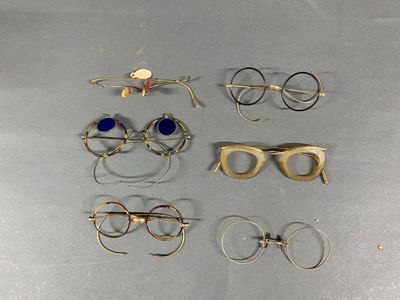 several pairs of glasses are sitting on a metal surface