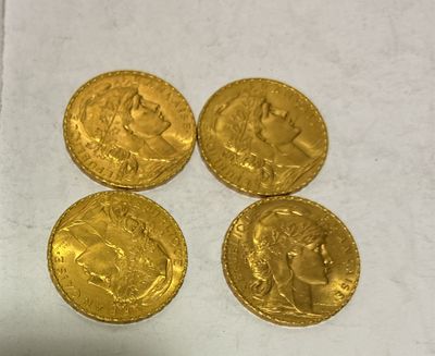 four gold coins sitting on top of a piece of paper