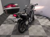 a motorcycle that is parked next to a car on the floor