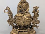 an image of a statue of a person sitting on top of a table