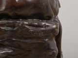 bronze statue of a man with a hat on his head and hands on his chest