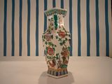 a vase that is sitting on a table in front of a striped wall