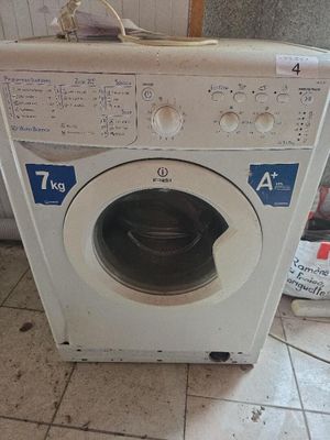 une machine à laver posée par terre dans la cuisine