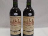 two bottles of wine sitting on top of a white table