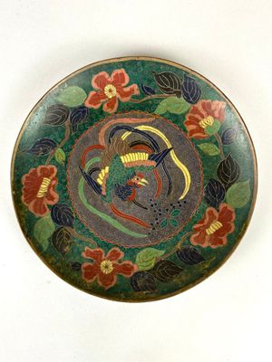 une assiette avec un oiseau et des fleurs