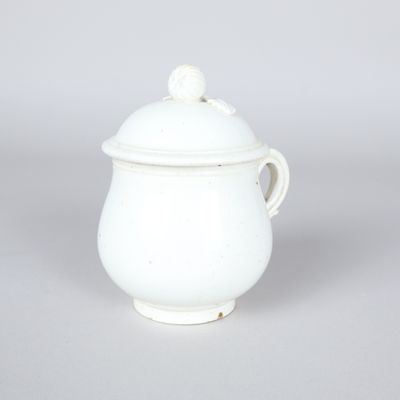 white porcelain teapot with a lid and a bird on the top