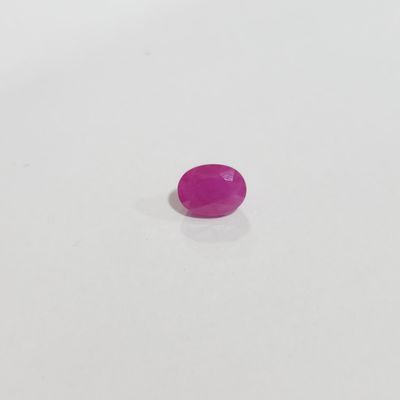 a pink plastic button sitting on top of a white surface