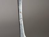 a silver spoon with a silver handle on a table