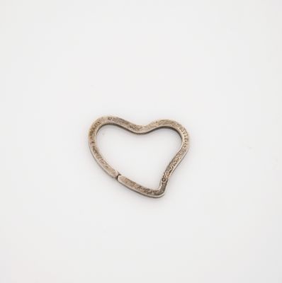 a close up of a metal heart shaped object on a white surface