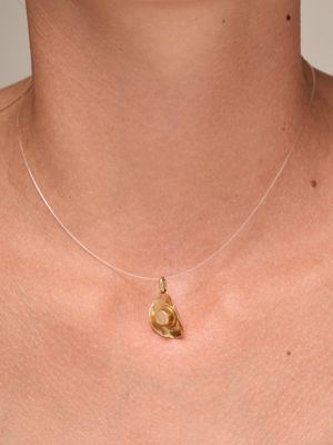 a close up of a woman wearing a gold necklace with a heart on it