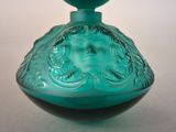 a green glass vase with a face on it