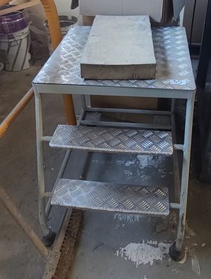 une photo d'une table en métal sur laquelle se trouve une boîte à pizza