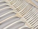 a lot of forks that are laying on a table