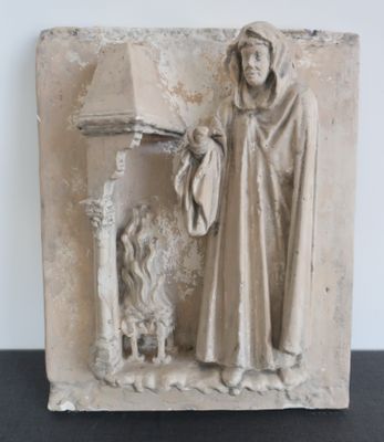 une statue représentant un homme debout près d'une cheminée
